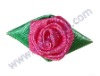 red satin ribbon rose with green leaf